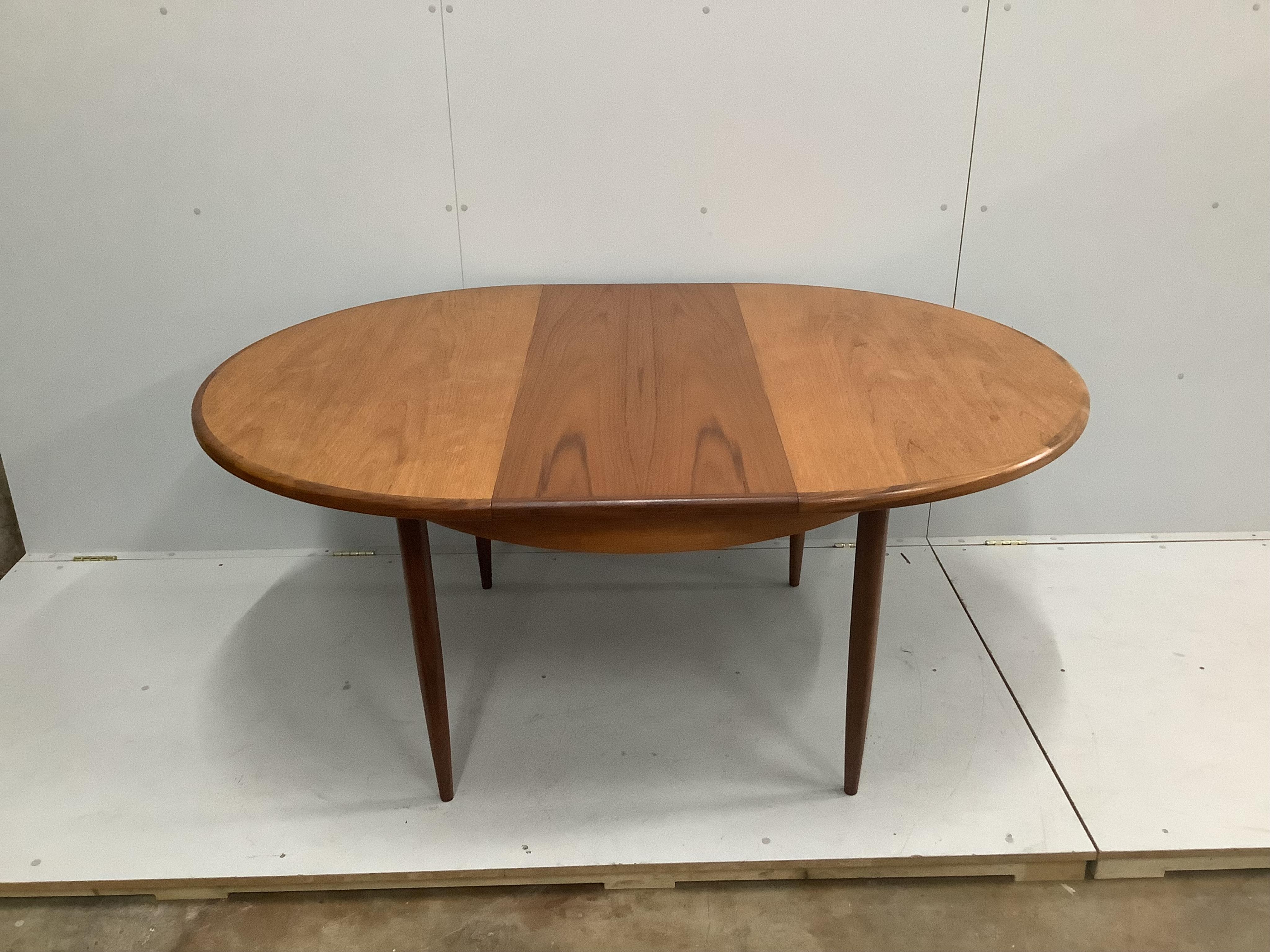 A mid century G Plan teak extending dining table, width 168cm extended, depth 122cm, height 73cm, together with six teak dining chairs. Condition - good